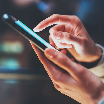 Hands typing on cell phone