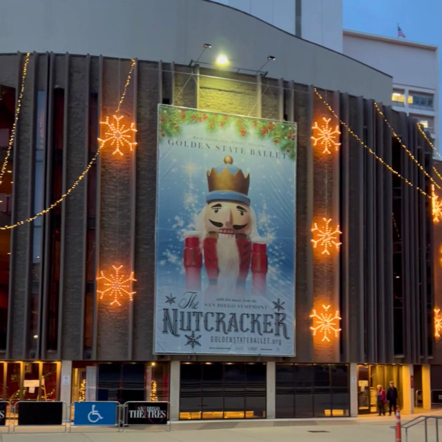 Holidays 2024 Facade of Civic Theatre with large light-up snowflakes and banner promoting The Nutcracker, complete with image of nutcracker, snow, holly, and text sharing show information from 2023.